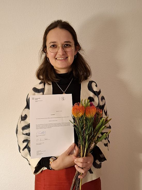 Michèle Ernste mit Dokument und Blumen